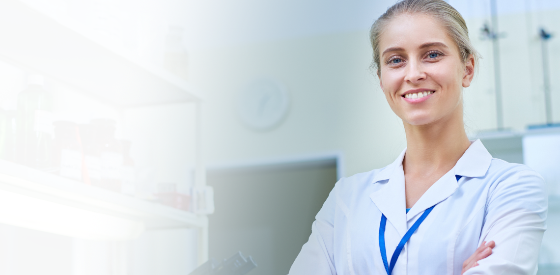 Female scientist in lab, smiling.